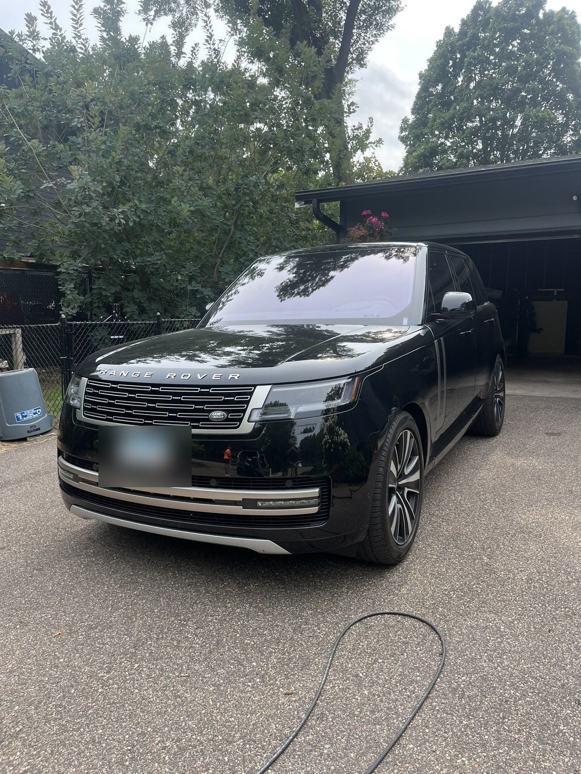 Freshly detailed black Range Rover in a Woodbury driveway